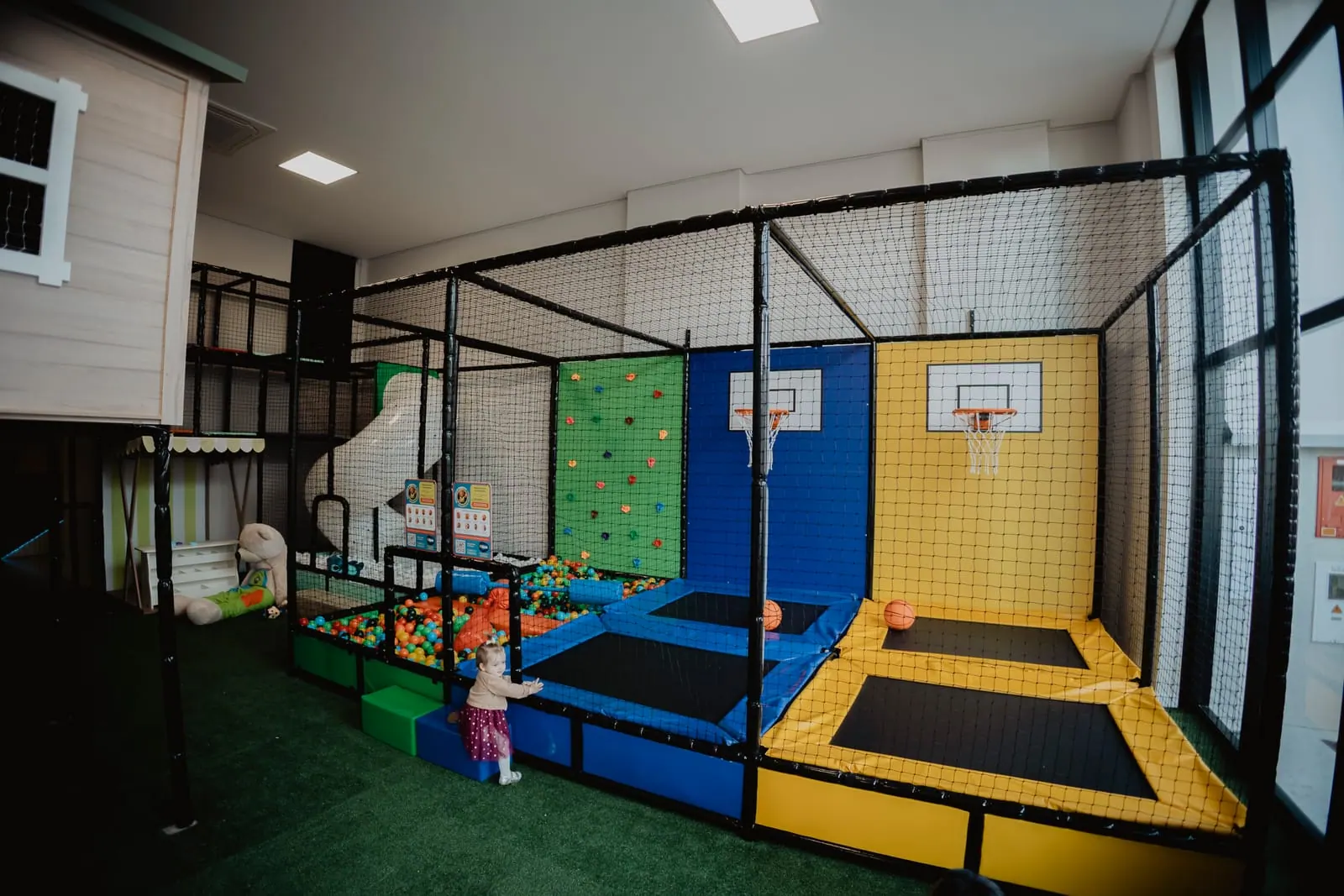 Arena de cama elástica com cestas de basquete e piscina de bolinhas